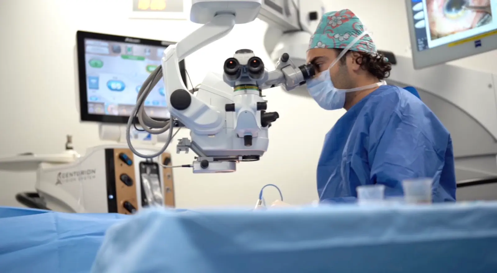Le Dr Fabien Rouimi au microscope opératoire, en tenue de bloc