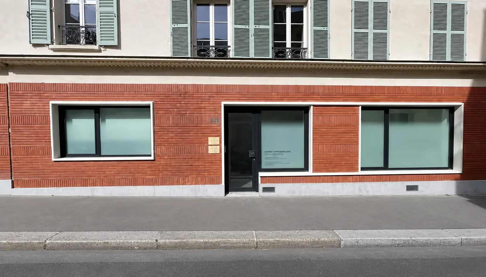 La façade de Dumoncel Ophtalmologie au 28 rue Rémy Dumoncel : rez-de-chaussée en brique rouge, grandes vitres dépolies et porte d'entrée vitrée.